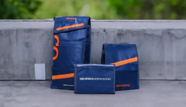 Boomerang Mehrwegversandtasche vor farbigem Hintergrund